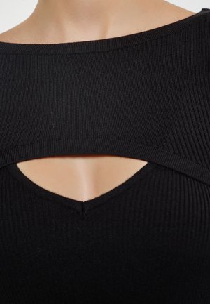 Top nero a coste con ampia scollatura e dettagli cut-out al centro. Il tessuto ha una texture liscia e una silhouette aderente.