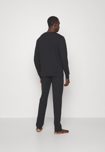 Black long-sleeve shirt and matching pants, made of soft fabric, with a relaxed fit and minimalistic design, viewed from the back.