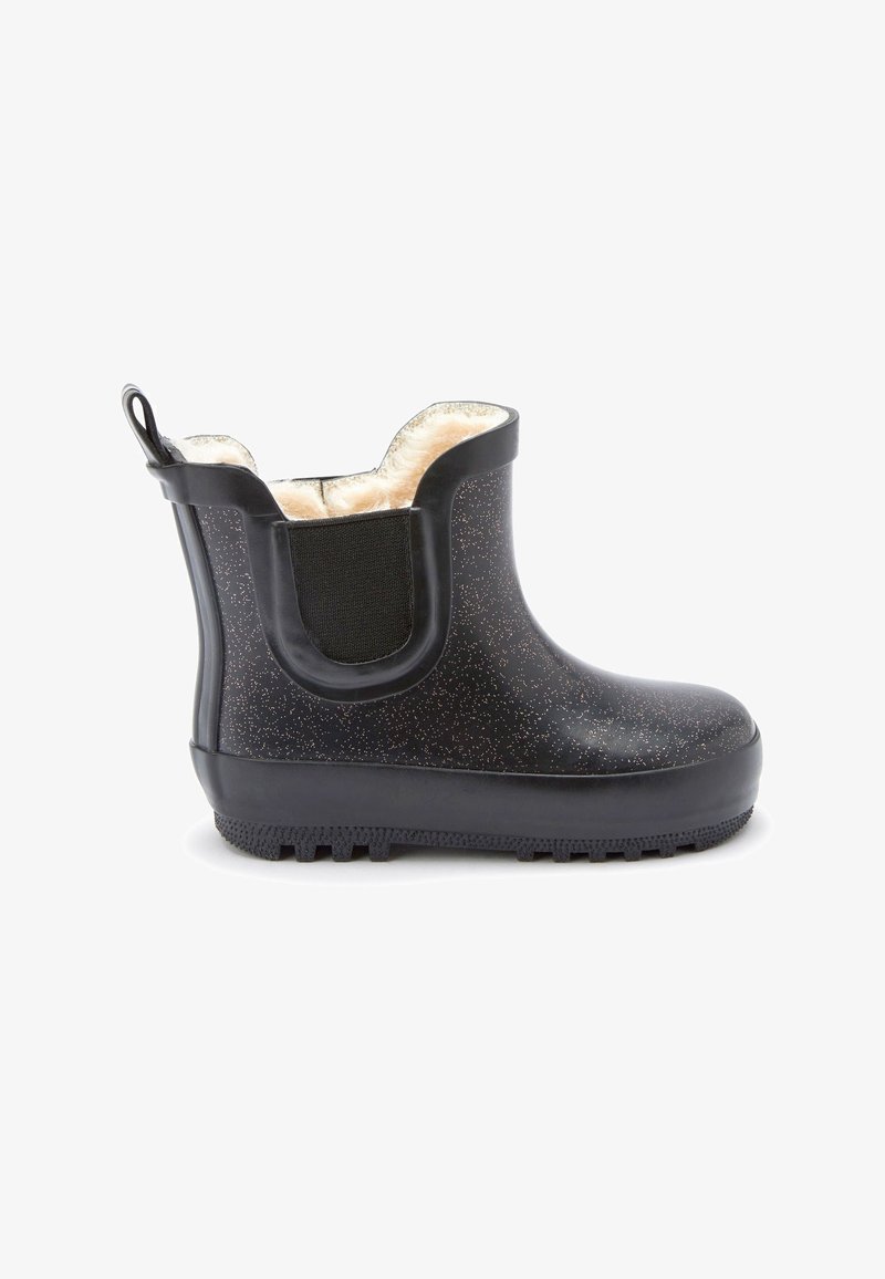 Botte de pluie en caoutchouc noire tachetée, montante à la cheville, avec un panneau latéral élastique et une doublure intérieure beige duveteuse, vue de côté extérieur.