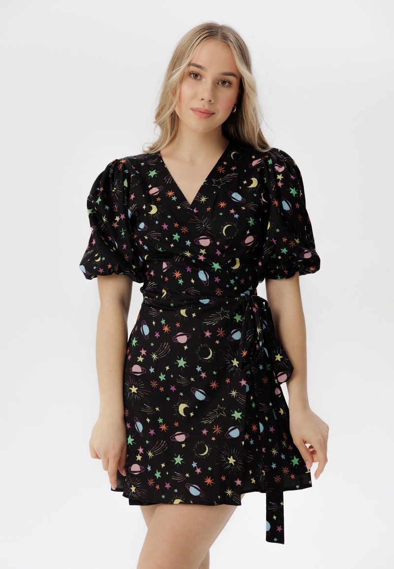 Vestido negro con un diseño envolvente, mangas abullonadas y patrones celestiales coloridos de estrellas y planetas. Tela ligera con una cintura ajustable con lazo.