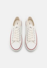 Oficialūs bateliai iš kanvos off-white spalvos su raudonais akcentais. Yra apvalus nosis, metaliniai akys ir plokščios raišteliai. Tekstūruota guma su raštuota briauna.