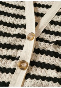 Gestreifter Cardigan mit abwechselnden strukturierten Streifen in Schwarz und Creme, mit V-Ausschnitt und einem großen, runden, klaren Knopf.