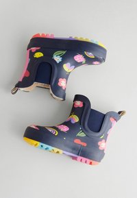 Bottes de pluie pour enfants en marine avec des motifs colorés de fleurs, de papillons et de coccinelles, semelles texturées multicolores et côtés élastiques en marine.