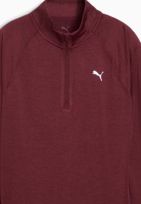 Haut long à manches maroon avec un col zippé à moitié et un logo Puma blanc sur la poitrine, conçu pour le sport.