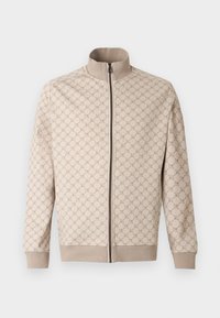 Veste beige avec un motif texturé, fermeture éclair intégrale et col montant. Comprend des poignets et un ourlet côtelés, confectionnée en tissu doux.