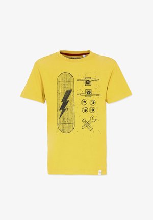 Keltainen puuvillapaita, jossa on musta graafinen kuva skeittilaudasta, salaman iskusta, pyöristä ja työkaluista. Paidassa on sileä pinta ja pyöreä kaula-aukko.