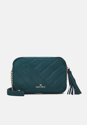 Tyrkis rektangulær crossbody taske med diagonalt quiltet mønster, guldkæde rem, lynlås med kvast og Anna Field-logo i guldskrift.