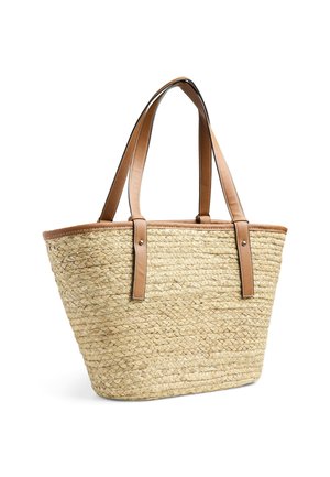 Słomkowa torba na ramię z dwoma brązowymi skórzanymi uchwytami i brązowym skórzanym wykończeniem. Wykonana z plecionki, z szerokim otworem i zwężającym się dnem.