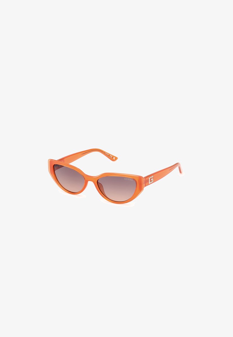 Gafas de sol en forma de ojo de gato de plástico naranja con lentes marrones degradados, que presentan un detalle del logo en las varillas y un acabado brillante y elegante.