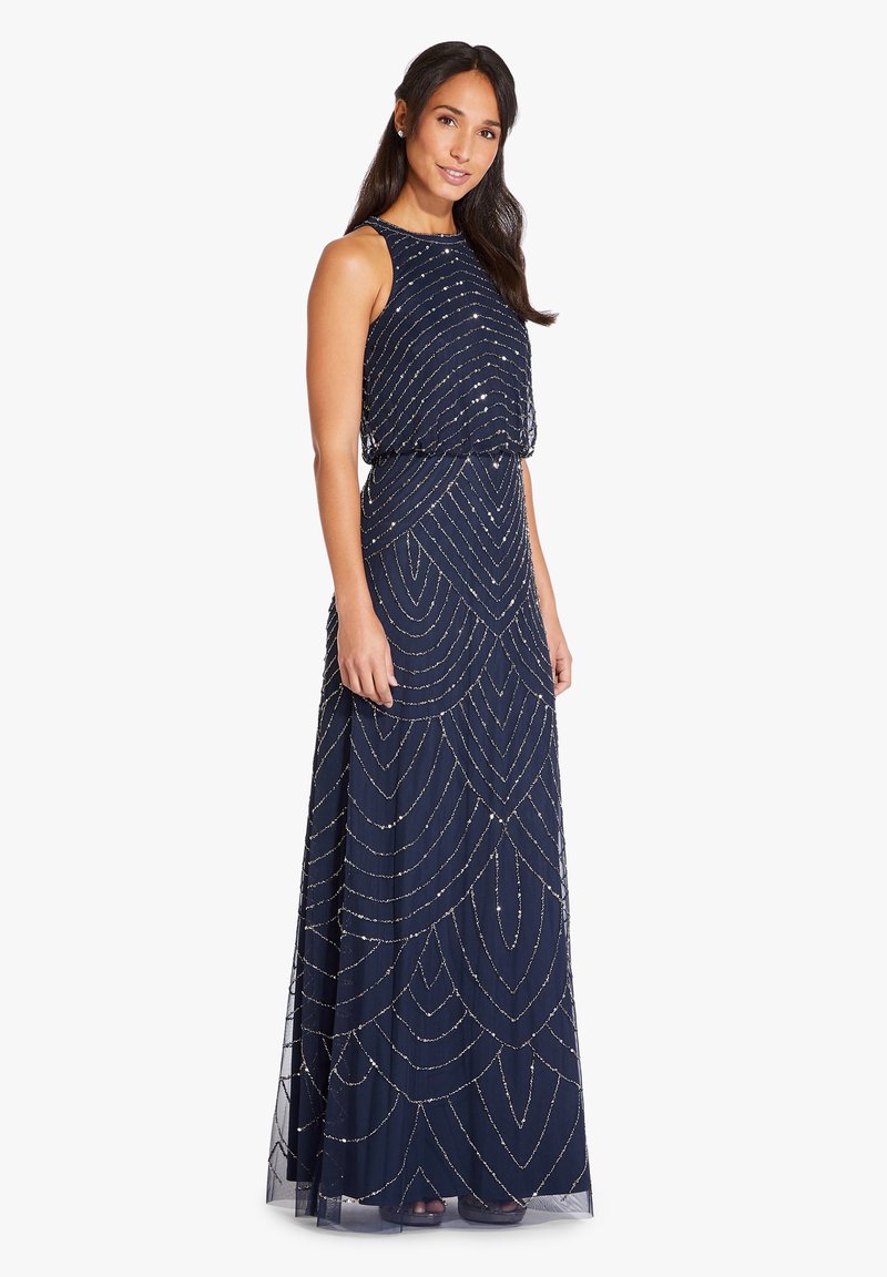 Robe de soirée bleu marine, longue, avec un motif géométrique en perles, sans manches, et une jupe fluide. Tissu doux avec une finition texturée.