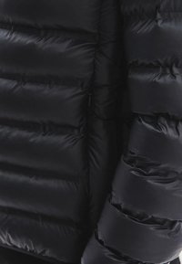 Czarna kurtka puchowa z pikowanym wzorem, z poziomymi segmentami i gładką, błyszczącą teksturą. Widoczny detal kieszeni na zamek.