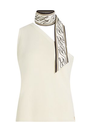 Crèmekleurige off-shoulder mouwloze top met een wit-zwart patroon sjaal gestrikt rond de halslijn.