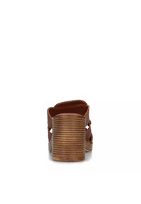 Sandali con tacco in pelle marrone con design a intaglio e tacco in legno rigato, che mettono in risalto una texture liscia e una silhouette moderna.
