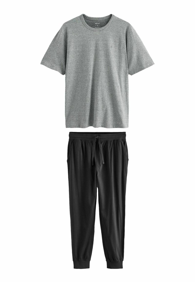 Grå kortærmet t-shirt med rund halsudskæring, parret med sorte joggerbukser med elastisk talje og ankelsnit.