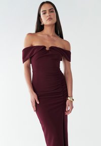 Burgundi värvi õlgadelt avatud kleit, millel on volditud külje detail ja väike võtmeauguga avaus krae piirkonnas. Valmistatud siledast, venivast kangast.