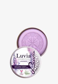 Luvia laventeli vegaaninen meikkisiveltimen saippua pyöreässä tinassa. Vaaleanlila saippua, jossa on kuvioitu pinta, ja joka on varustettu kukkakuviolla ja logoilla.