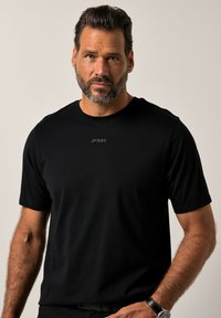 T-shirt nera a maniche corte realizzata in tessuto morbido, con un piccolo e discreto logo JP1880 sul davanti. Design casual e aderente.