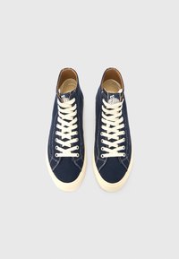 Ναυτικά πάνινα ψηλά παπούτσια με μπεζ κορδόνια, λαστιχένιες σόλες και παιδικό σχέδιο στη γλώσσα. Υφασμάτινη υφή με αντίθετη ραφή.