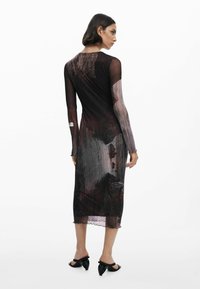Langärmliges Kleid aus transparentem schwarzem Stoff mit abstrakten, malerischen Mustern in dunklem Rot und Braun, mit einem wellenförmigen Saum und Knopfdetail hinten.