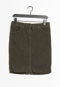 Jupe en velours côtelé vert olive avec des boutons sur le devant et des poches, suspendue à un cintre en plastique noir sur fond blanc.