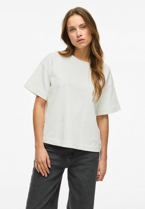 Lichtgrijze t-shirt met korte mouwen, een ronde halslijn en een ontspannen pasvorm, gemaakt van katoenen stof, gecombineerd met donkergrijze jeans.