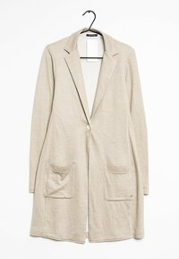 Beżowy długi kardigan wykonany z lekkiego materiału. Posiada wycięty kołnierz, zapięcie na pojedynczy guzik oraz dwie przednie kieszenie.