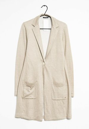 Beige lange cardigan gemaakt van lichtgewicht stof. Heeft een geknipt kraag, een enkele knoopsluiting en twee voorzakken.