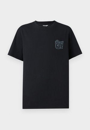 Camiseta de algodón negra con mangas cortas, que presenta un logo en el bolsillo frontal en un tono ligeramente más claro. Cuello redondo, corte estándar.