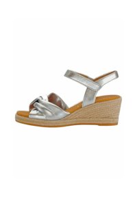 Silberne metallische Keil-Sandalen mit einer gewebten Seilsohle, die ein geknotetes Vorderdesign und einen verstellbaren Knöchelriemen für einen sicheren Sitz aufweisen.