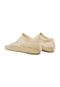 Scarpe slip-on beige in mesh con suola bassa, caratterizzate da un modello di tessitura aperta e una morbida finitura attorno alla caviglia per maggiore comfort.