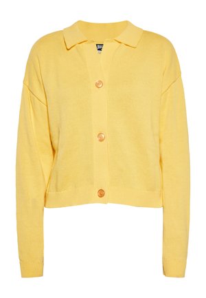 Cardigan en maille jaune avec un col, cinq grands boutons et une coupe courte. La texture est lisse avec des poignets et un ourlet côtelés.