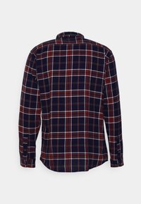 Camicia a maniche lunghe a quadri in blu navy con motivi a scacchi rossi e bianchi. Presenta un colletto standard e polsini con bottoni. Design aderente.