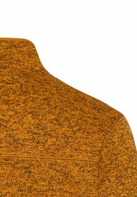Sweater i en tekstureret, brændt orange stof med et subtilt mønster, rundt krave og en sømdetalje på tværs af ryggen.