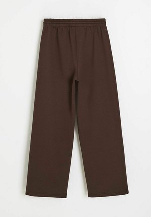 Brązowe, szerokie spodnie dresowe z elastycznym pasem, przedstawione na płasko na białym tle.