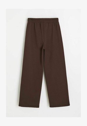 Brązowe, szerokie spodnie dresowe z elastycznym pasem, przedstawione na płasko na białym tle.