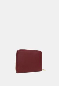 Portafoglio in pelle bordeaux con finitura texturizzata, forma rettangolare e accentuazione in zip dorata. Design compatto adatto per carte e contante.