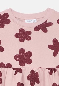 Ροζ βαμβακερό φόρεμα με μοβ λουλουδένιο μοτίβο, ριμπ λαιμόκοψη, και συγκεντρωμένη μέση. Μαλακή υφή με παιχνιδιάρικο λουλουδάτο σχέδιο.