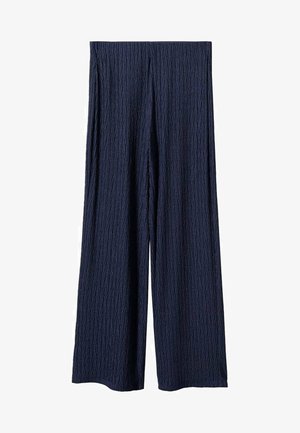 Haut texturé bleu marine à manches courtes, rentré dans un pantalon assorti, avec une ceinture noire à boucle métallique pour un détail supplémentaire.