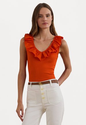 Bodysuit orange à côtes avec un décolleté en V profond et un col volanté, associé à un pantalon blanc taille haute avec des boutons dorés et une ceinture marron.