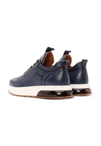 Marine lederen sneakers met een gladde textuur, witte zool, bruine binnenkant en transparante zwarte hielaccent. Kenmerkt een vetersluiting en trektabs.