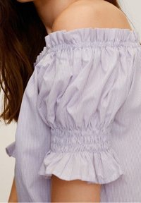 Top off-the-shoulder con maniche a palloncino, caratterizzato da un motivo a righe bianche e lilla, vita elasticizzata arricciata e dettagli con volant.