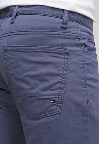 Mörkblå bomullsbukser med rak passform, med en bakficka som har en liten logotagg i röd, vit och blå, samt detaljerad sömnad.