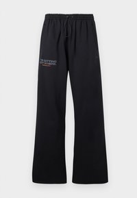 Μαύρες φόρμες με χαλαρή εφαρμογή, με ελαστική μέση και κορδόνι, πλαϊνές τσέπες και τυπωμένο κείμενο στο μηρό σε αντίθετους χρωματισμούς.