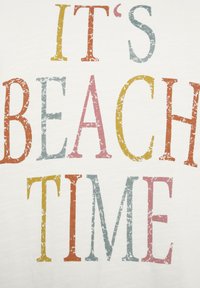 Witte stof met grote, vervaagde tekst in oranje, geel, roze en blauw met de tekst "HET IS STRANDTIJD."