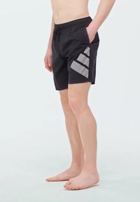 Bañador negro con cintura ajustable, que presenta un patrón geométrico gris en el costado. Fabricado con material ligero y duradero.