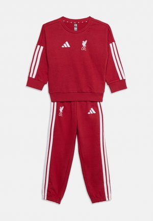 Conjunto rojo de sudadera de manga larga y pantalones con rayas blancas de Adidas y logotipos del Liverpool FC en el pecho y el muslo.