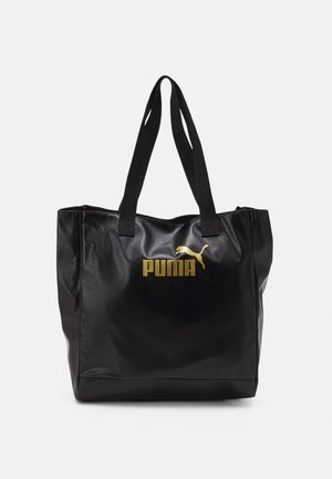 Zwarte getextureerde tote bag met dubbele schouderbanden en gouden Puma-logo gedrukt aan de voorzijde in het midden.
