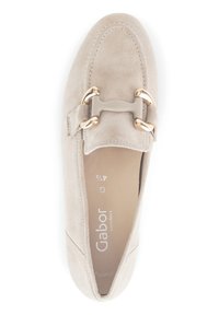 Beige suede moccasin shoe with a rounded toe, featuring a gold-tone hardware accent and stitched detailing along the sides.
