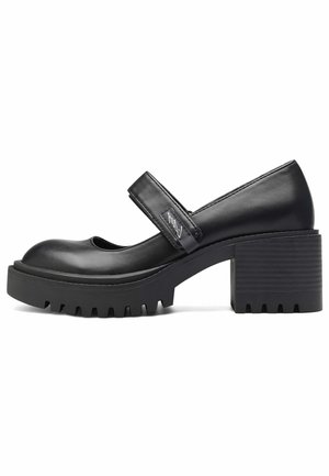 Chaussures Mary Jane en cuir noir avec un bout arrondi, une plateforme épaisse et une semelle extérieure en caoutchouc texturé. Dotées d'une bride large sur le cou-de-pied.