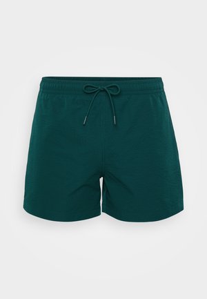 Donkerblauwe zwemshorts met een gestructureerde stof, elastische tailleband en een trekkoordsluiting met metalen uiteinden.